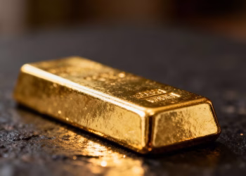 Lingot d'or brillant sur fond sombre.