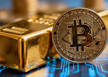 Barre d'or et pièce de cryptomonnaie côte à côte.