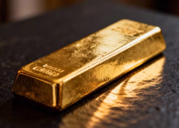 Lingot d'or brillant sur fond sombre.