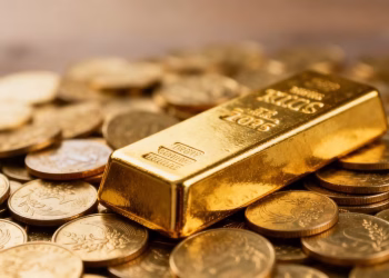 Lingot d'or sur des pièces d'or, symbole d'investissement.
