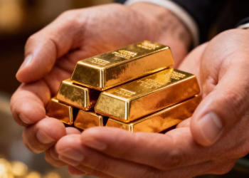 Mains tenant des lingots d'or brillants.