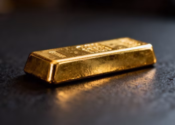 Lingot d'or brillant sur fond sombre.