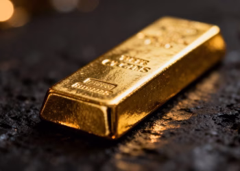 Lingot d'or brillant sur fond sombre.