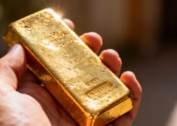 Barre d'or brillante tenue dans une main.