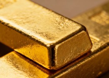 Lingot d'or brillant sur fond sombre.
