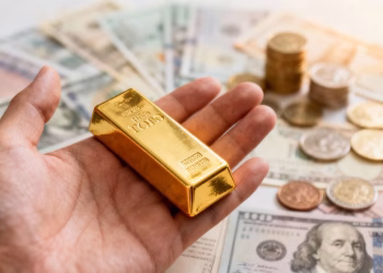 Main d'or tenant une barre d'or avec des actifs financiers diversifiés.