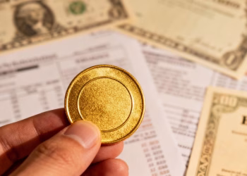 Main d'or tenant une pièce d'or, portefeuille diversifié.