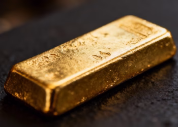 Lingot d'or brillant sur fond sombre.