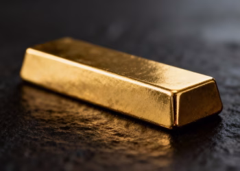 Lingot d'or brillant sur fond sombre.