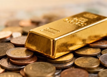 Barre d'or sur des pièces, symbolisant la stabilité financière.