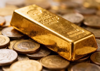Barre d'or sur des pièces, symbole de richesse et de protection.