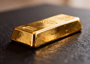 Lingot d'or brillant sur fond sombre.