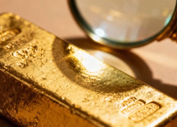 Barre d'or sous une loupe, certification d'authenticité.