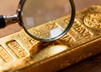 Lingot d'or sous une loupe, gros plan.