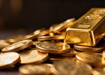 Lingots et pièces d'or brillants sous la lumière.