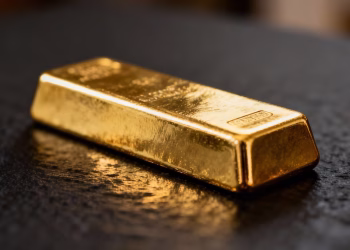 Lingot d'or brillant sur fond sombre.