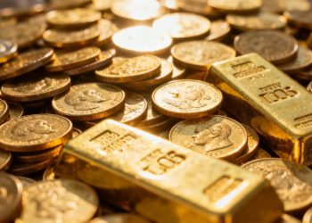 Pièces et lingots d'or brillants, symbolisant la richesse historique.