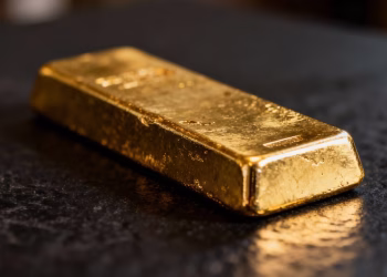 Lingot d'or brillant sur fond sombre.