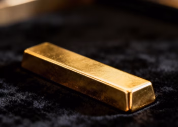 Lingot d'or brillant sur fond sombre.