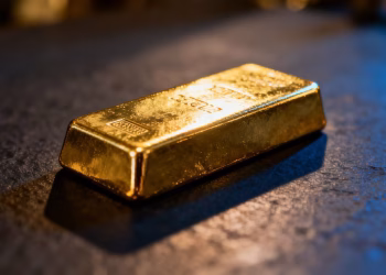 Lingot d'or brillant sur fond sombre.