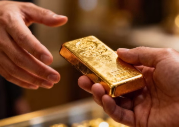Main dorée tenant une barre d'or brillante, pièges à éviter.
