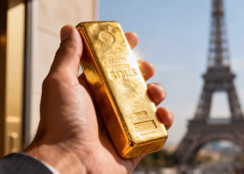 Main d'or tenant une barre d'or devant la Tour Eiffel.