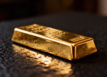 Lingot d'or brillant sur fond sombre.
