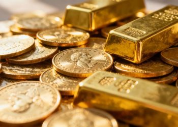 Lingots et pièces d'or brillants sous la lumière.