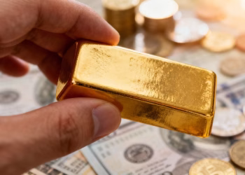 Main d'or tenant une barre d'or avec des actifs financiers diversifiés.