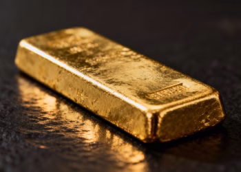 Lingot d'or brillant sur fond sombre.