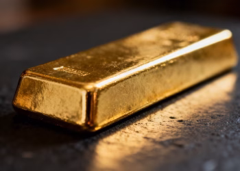 Lingot d'or brillant sur fond sombre.