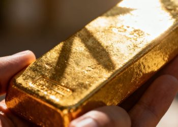 Barre d'or brillant dans une main