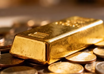 Barre d'or et pièces de monnaie, symbole de protection de l'épargne.