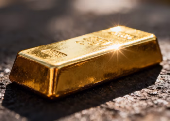 Lingot d'or brillant sur fond sombre.