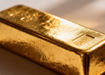 Lingot d'or brillant, gros plan, sur fond flou.