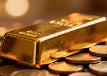 Lingot d'or sur une pile de pièces de monnaie.