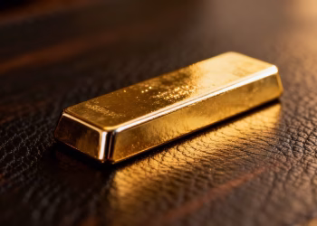 Lingot d'or brillant sur fond sombre.