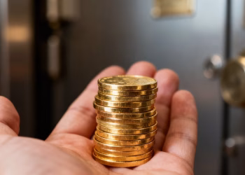 Main d'une personne tenant des pièces d'or.