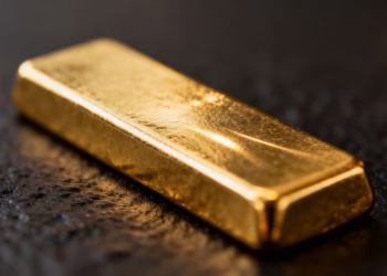 Lingot d'or brillant sur fond sombre.