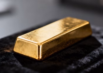 Lingot d'or sur fond sombre, reflet métallique.