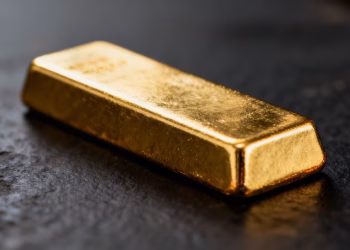 Lingot d'or brillant sur fond sombre.