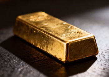 Lingot d'or brillant sur fond sombre.