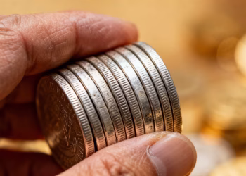 Main d'une personne tenant des pièces d'argent.