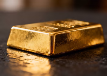 Lingot d'or brillant sur fond sombre.