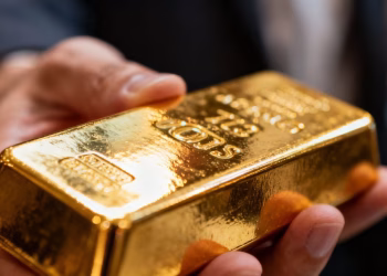 Personne tenant une barre d'or brillante.