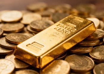 Lingot d'or sur des pièces d'or, symbolisant la richesse.