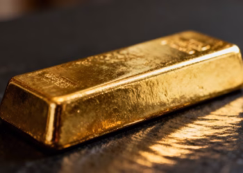 Lingot d'or brillant sur fond sombre.