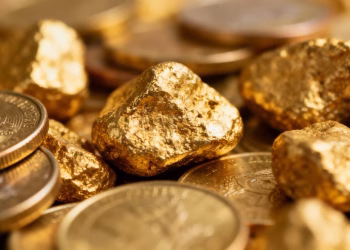 Lingots et pièces d'or brillants, gros plan.