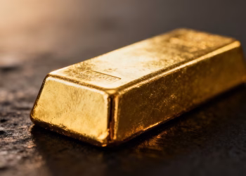 Lingot d'or brillant sur fond sombre.