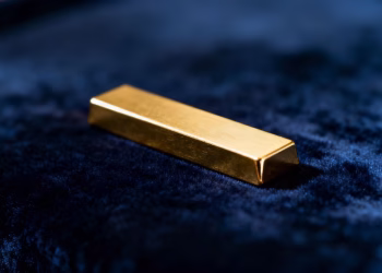 Lingotin d'or brillant sur fond sombre.